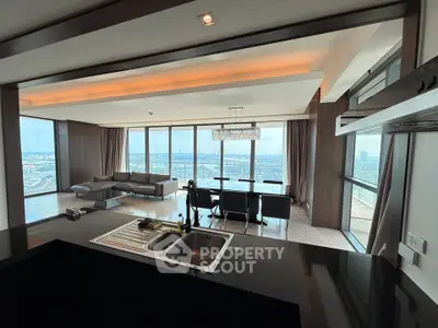 Luxurious open-plan living room with panoramic city views and modern furnishings.