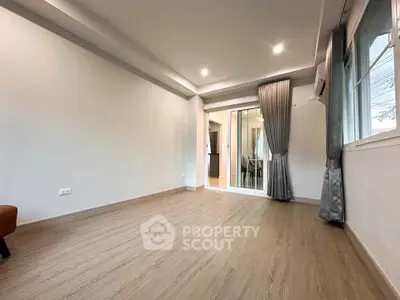 Spacious modern living room with wooden flooring and sliding glass doors.