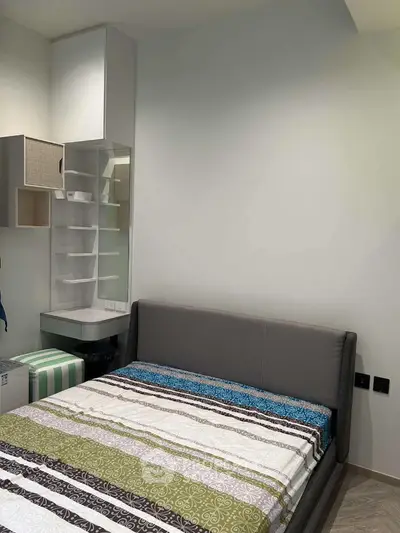 Cozy bedroom with modern bed and built-in storage, perfect for urban living.