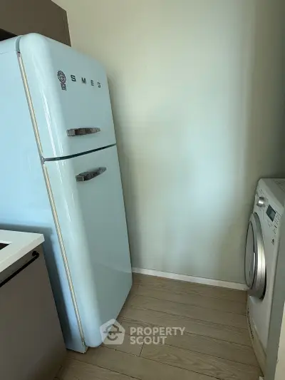 Chic kitchen corner with retro SMEG fridge and modern washing machine.