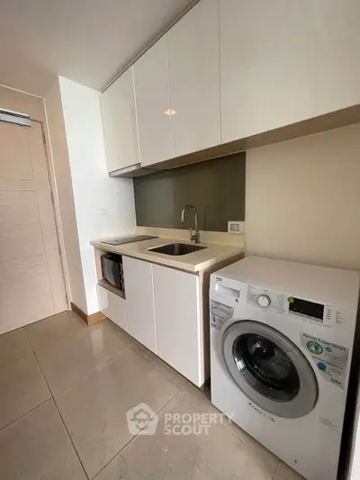 Modern kitchen with sleek cabinetry and built-in washing machine