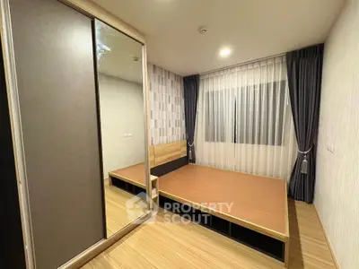 Modern bedroom with wooden flooring and large mirrored wardrobe