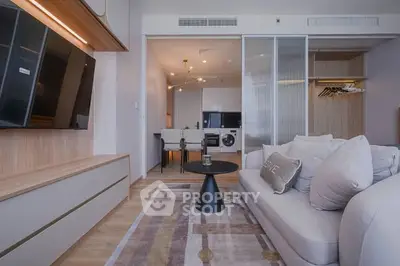 Modern living room with sleek furniture and open kitchen layout in stylish apartment.