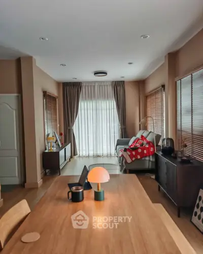 Cozy living room with modern decor and natural light, featuring a stylish table lamp and comfortable seating.