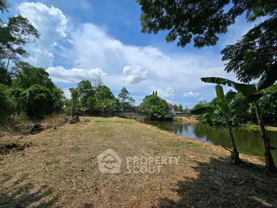 Expansive land with lush greenery and serene pond, perfect for development or private retreat.