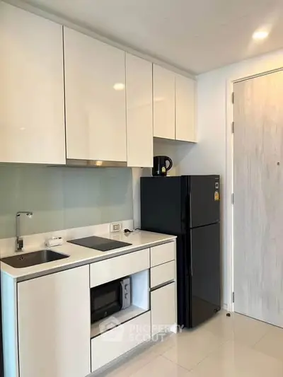 Modern kitchen with sleek cabinetry and appliances in a stylish apartment.