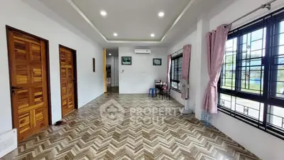 Spacious living room with elegant herringbone flooring and large windows