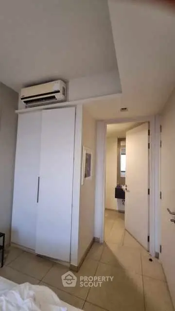 Modern bedroom with air conditioning and sleek white closet doors