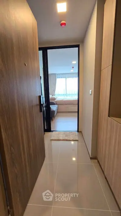Modern apartment entrance with view into a cozy living room featuring stylish decor.