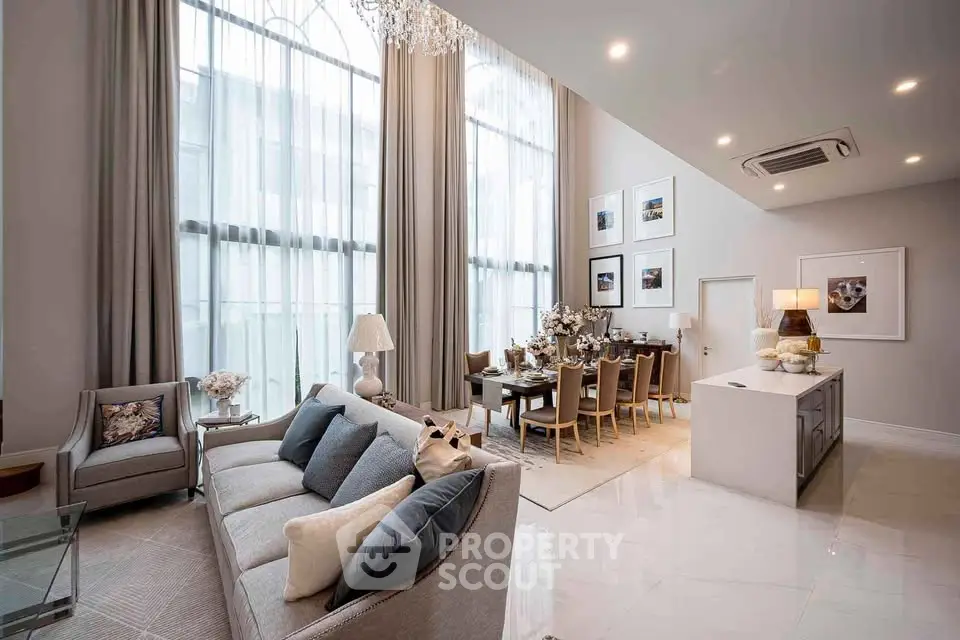 Luxurious high-ceiling living room with elegant decor and dining area in modern apartment.