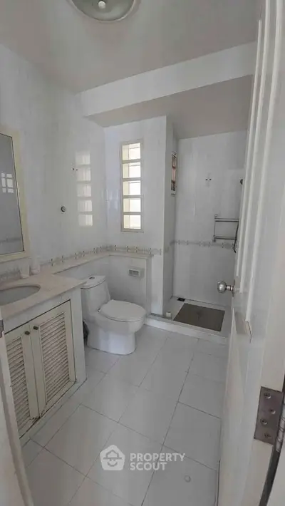 Spacious bathroom with modern fixtures and elegant white tiles