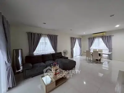 Spacious modern living room with elegant dining area and large windows.
