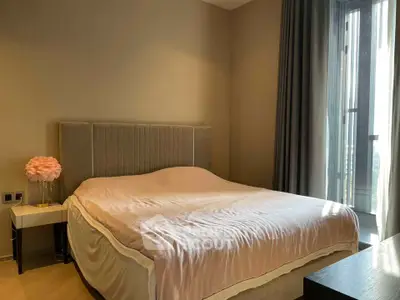 Luxurious bedroom with elegant decor and large window offering natural light.