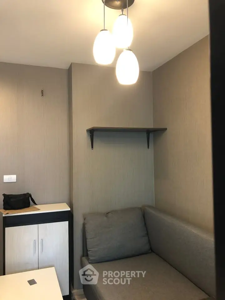 Cozy small living room with modern sofa and wall shelf, perfect for compact urban living.