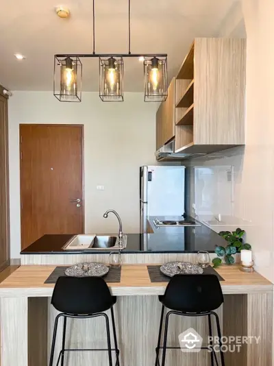 Modern kitchen with stylish lighting and breakfast bar seating