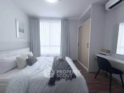 Cozy bedroom with modern decor and natural light, featuring a comfortable bed and stylish workspace.