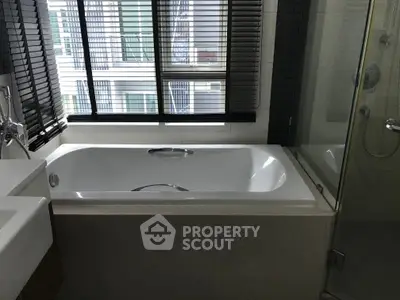 Modern bathroom with sleek bathtub and glass shower enclosure