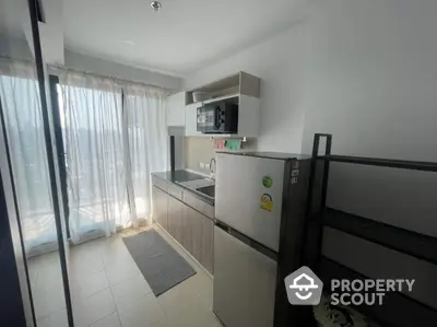 Modern kitchen with natural light, sleek cabinetry, and stainless steel appliances.