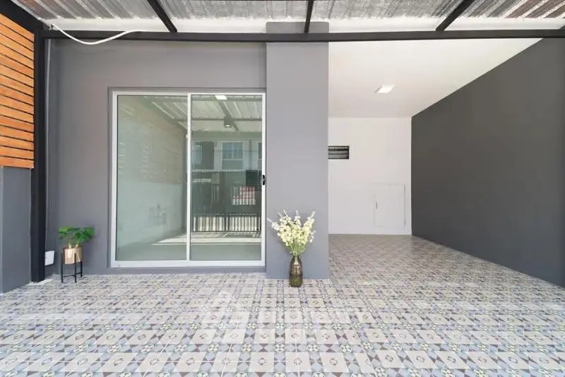 Modern covered patio with stylish tile flooring and sliding glass door