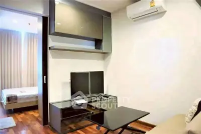 Modern living room with sleek furniture and air conditioning, adjacent to a cozy bedroom.