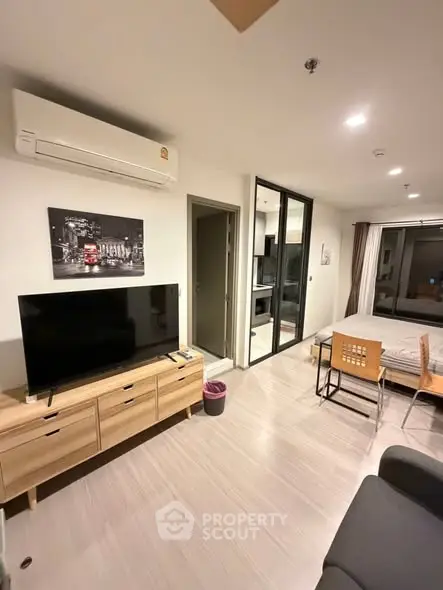 Modern living room with TV, air conditioning, and stylish decor in a cozy apartment.