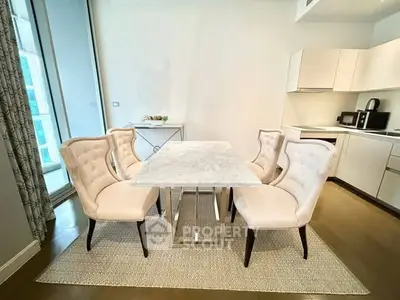Elegant dining area with marble table and plush chairs in modern kitchen setting.
