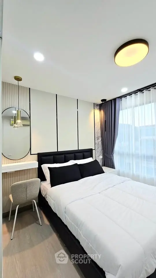 Modern bedroom with stylish decor and large window for natural light