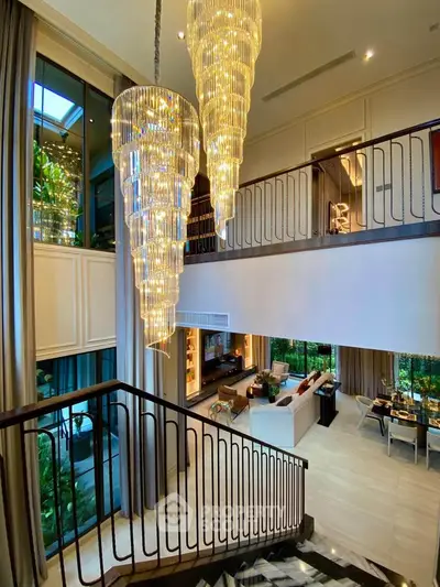 Luxurious double-height living room with grand chandeliers and elegant decor