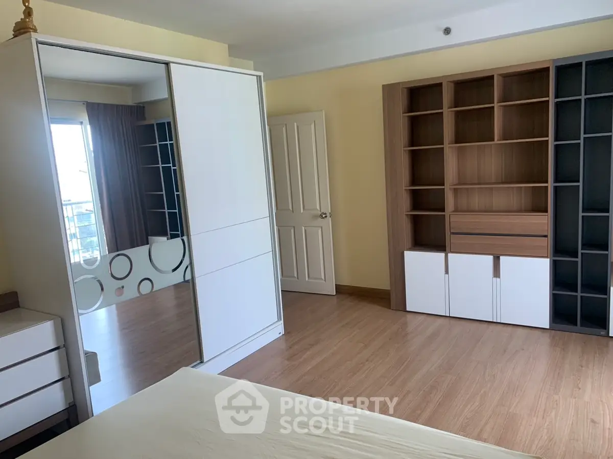 Spacious bedroom with modern wardrobe and ample shelving