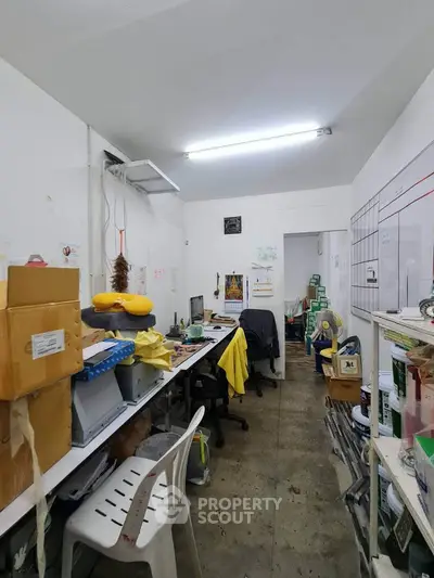 Compact office space with desks, chairs, and storage boxes, ideal for small business operations.