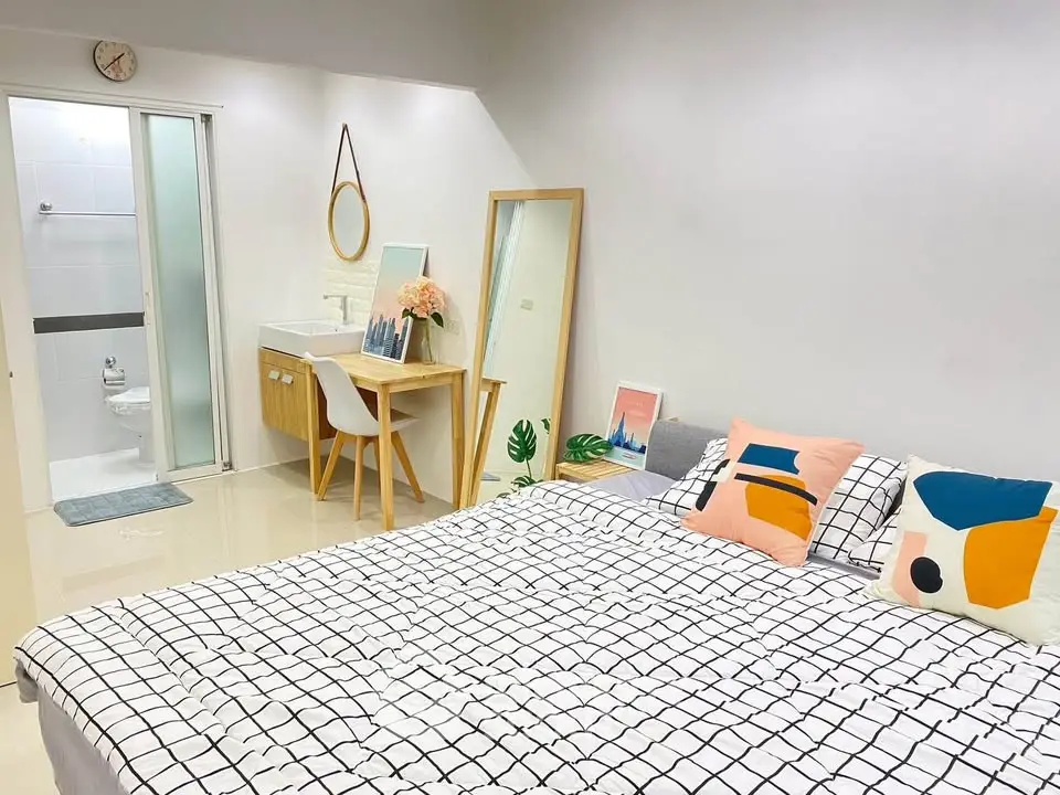 Modern bedroom with stylish decor and ensuite bathroom, featuring a cozy bed and chic furnishings.