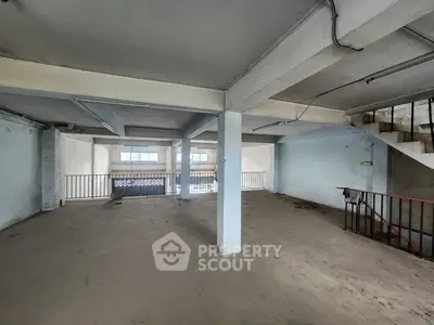 Spacious unfinished interior with concrete floors and exposed beams, ideal for customization.