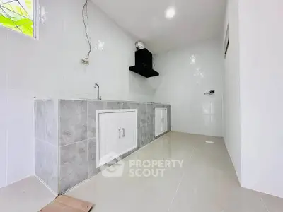 Modern minimalist kitchen with sleek white cabinetry and tiled flooring