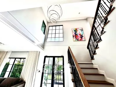 Stunning modern living room with high ceilings and elegant staircase