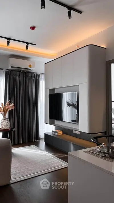 Modern living room with sleek TV unit and elegant lighting in a stylish apartment.