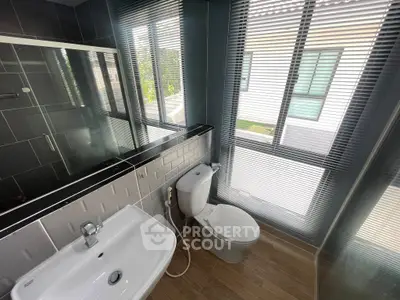 Modern bathroom with sleek fixtures and large windows offering natural light.