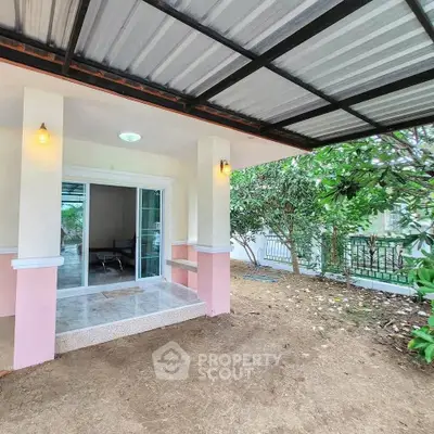 Charming home entrance with covered patio and lush garden view