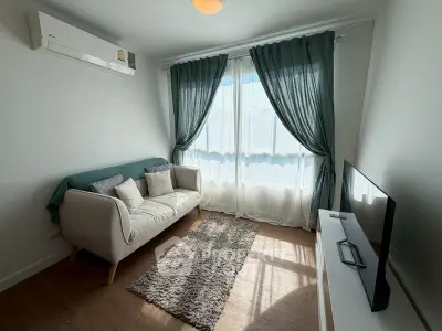 Cozy living room with natural light, modern sofa, and TV setup