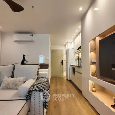 Modern living room with open kitchen, stylish decor, and cozy ambiance in a contemporary apartment.