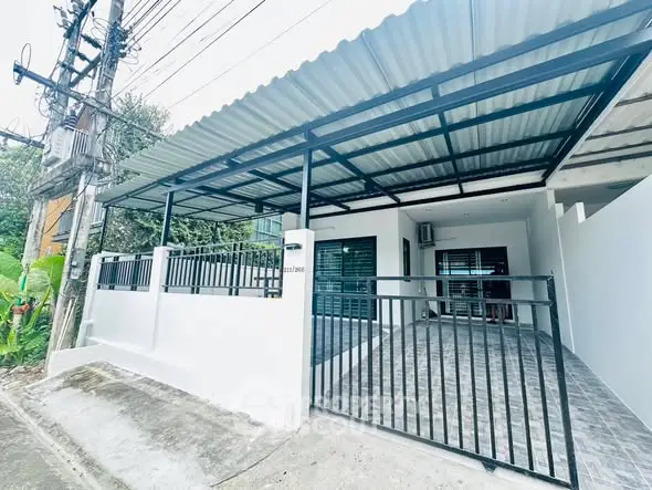 Modern single-story home with gated entrance and covered carport in a suburban setting.