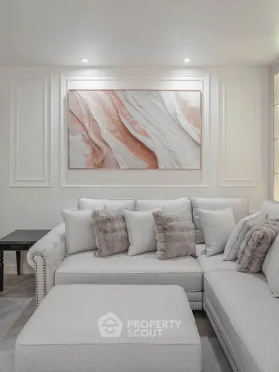 Elegant living room with plush sectional sofa and modern art decor, perfect for stylish relaxation.