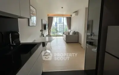 Modern open-plan living room with city view, sleek kitchen, and cozy seating area.