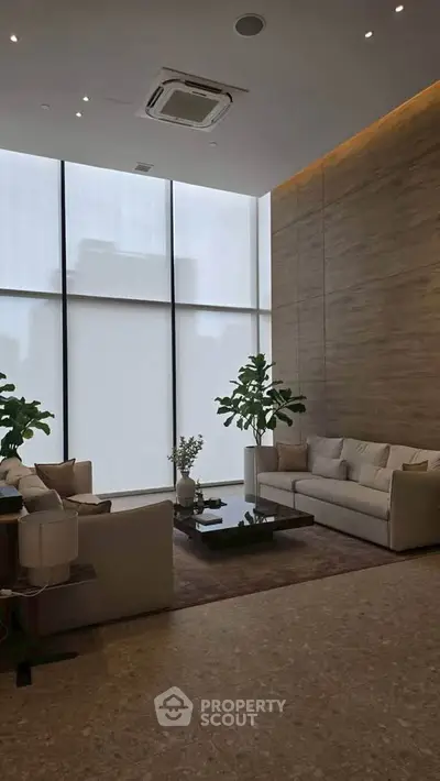 Luxurious modern living room with high ceilings and elegant decor, featuring large windows and stylish furniture.