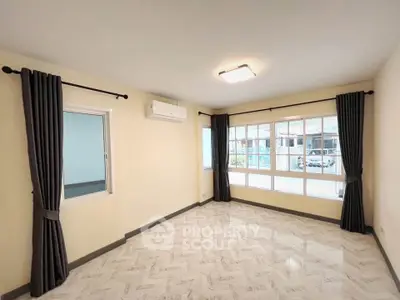Spacious living room with large windows and modern lighting