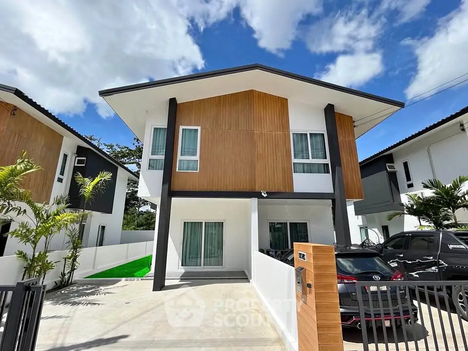 Modern two-story house with sleek design and spacious driveway in a sunny neighborhood.