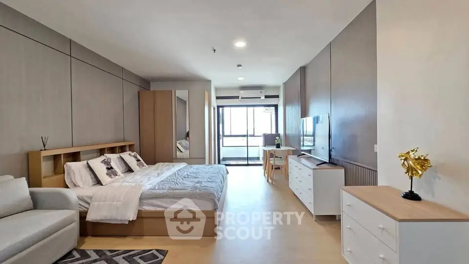 Spacious modern bedroom with stylish decor and balcony view