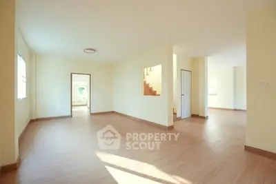 Spacious empty living room with wooden flooring and natural light