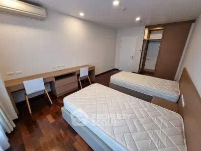 Spacious bedroom with twin beds and modern wooden flooring