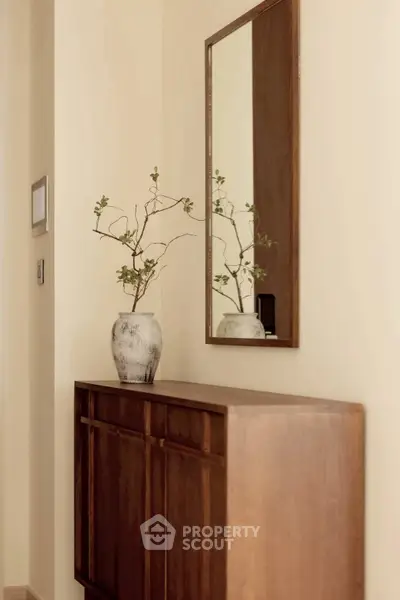 Elegant hallway with wooden console and decorative mirror, perfect for modern interiors.