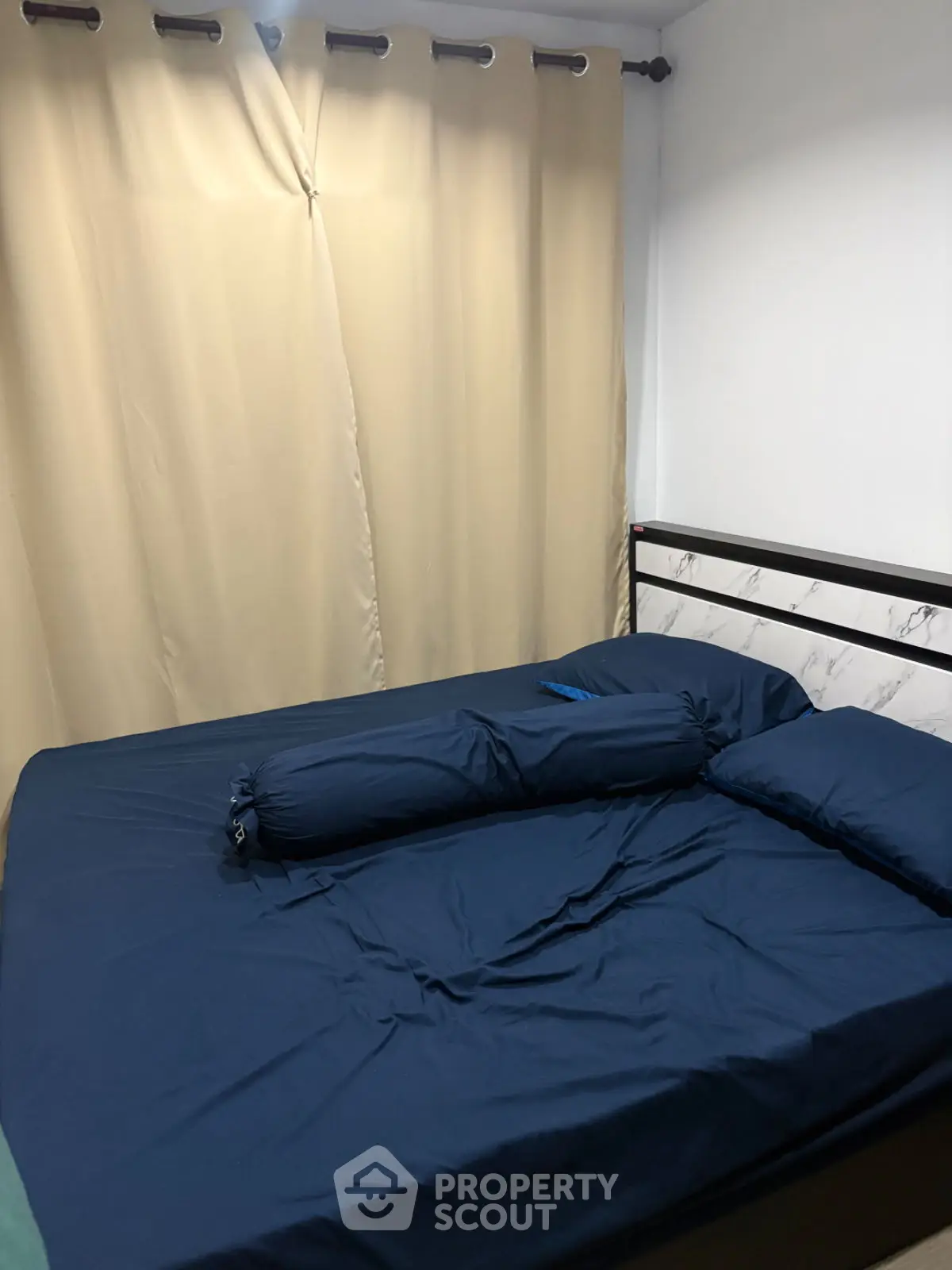 Cozy bedroom with navy blue bedding and elegant curtains
